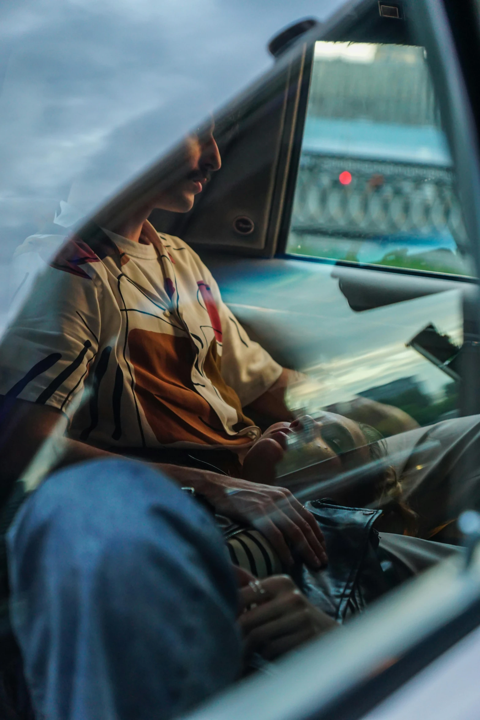 a man sitting in the passenger seat of a car, inspired by Elsa Bleda, streetwear, zoomed in, people at work, student