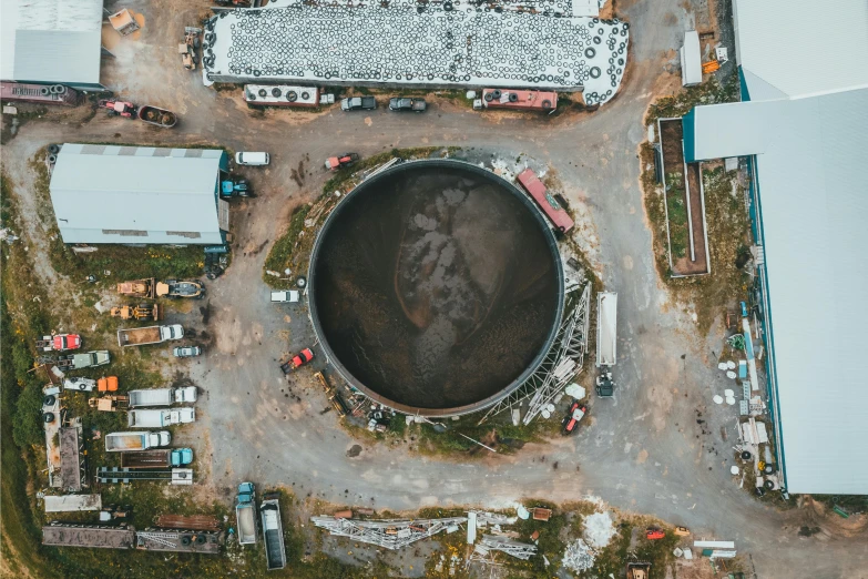 a large tank sitting in the middle of a parking lot, pexels contest winner, process art, huge black round hole, biroremediation plant, aerial spaces, metal towers and sewers