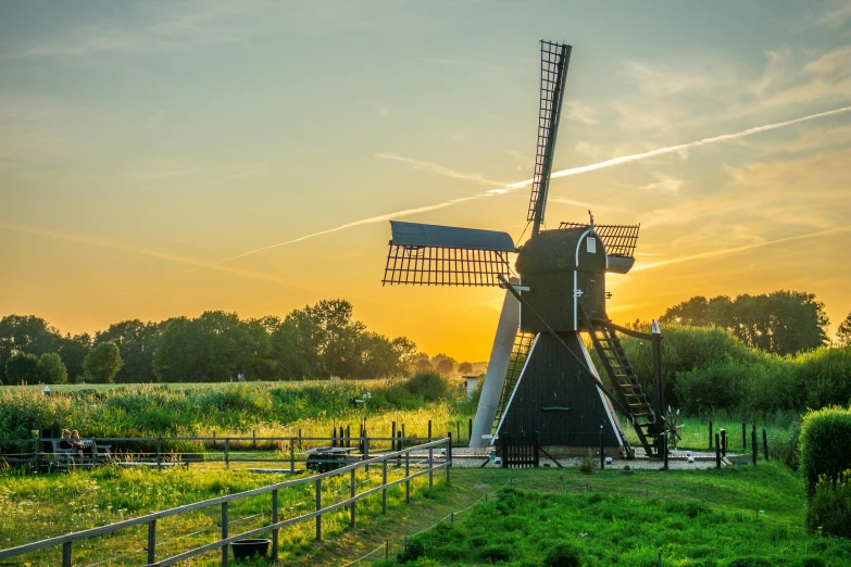 a windmill sitting on top of a lush green field, by Jan Tengnagel, pexels contest winner, golden hour”, waterwheels, jan vermeer, where a large