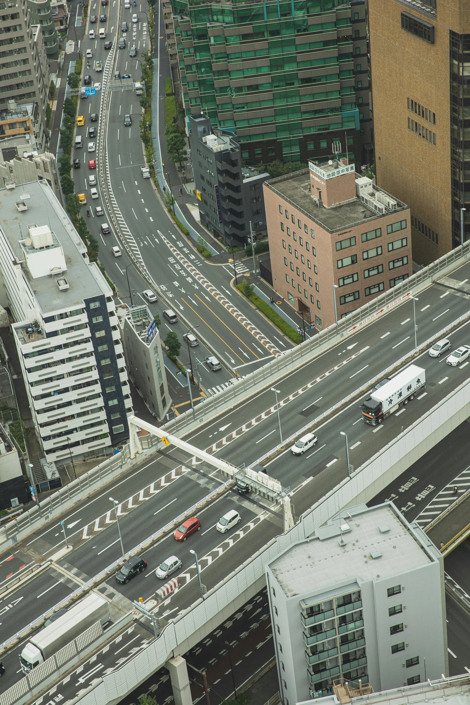 a city filled with lots of traffic next to tall buildings, inspired by Yasushi Sugiyama, unsplash, overpass, square, gigapixel photo, new zealand