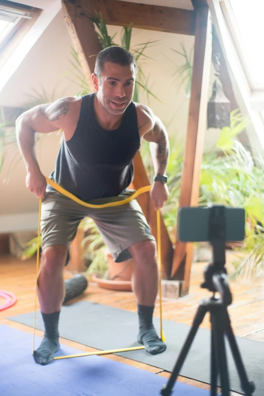 a man standing on a yoga mat in front of a camera, hoses, athletic man in his 30s, everything fits on the screen, australian