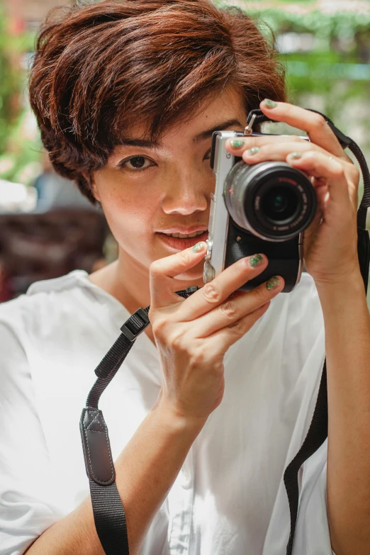 a woman taking a picture with a camera, androgynous male, cindy avelino, lovingly looking at camera, zoomed in