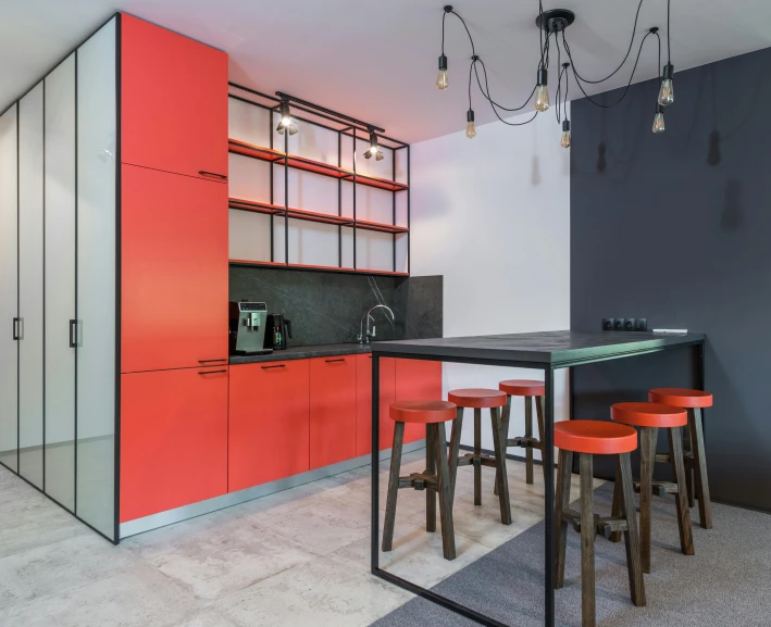 a kitchen with red cabinets and black counter tops, by Adam Marczyński, unsplash contest winner, altermodern, cubical meeting room office, neo kyiv, orange grey white, retro style ”