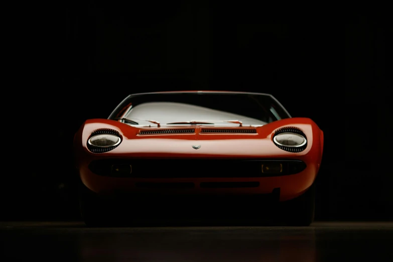 a red sports car in a dark room, pexels contest winner, photorealism, medium format. soft light, miura, 3/4 front view, prototype car