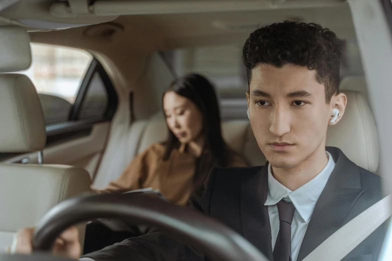 a man and a woman sitting in a car, inspired by Zhang Xiaogang, trending on pexels, wearing a strict business suit, concerned expression, jordan grimmer and natasha tan, ethnicity : japanese