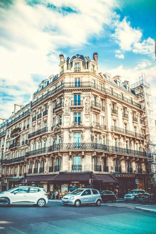 a group of cars driving down a street next to tall buildings, a photo, pexels contest winner, paris school, ornate french architecture, square, a blond, stores