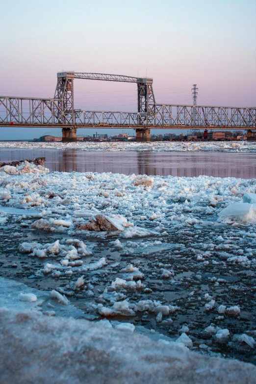 a frozen body of water with a bridge in the background, a portrait, flickr, red river, slide show, 2022 photograph, hziulquoigmnzhah