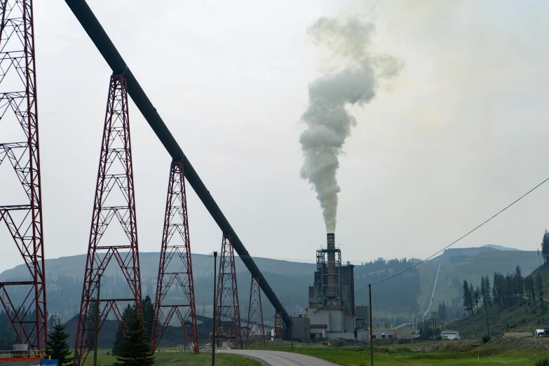 a factory with a lot of smoke coming out of it, by Everett Warner, pexels contest winner, hurufiyya, montana, sweaty mountain, with pipes attached to it, july 2 0 1 1