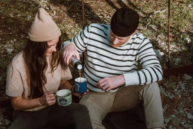 a man and a woman sitting next to each other, trending on pexels, forest picnic, aussie baristas, striped, blue