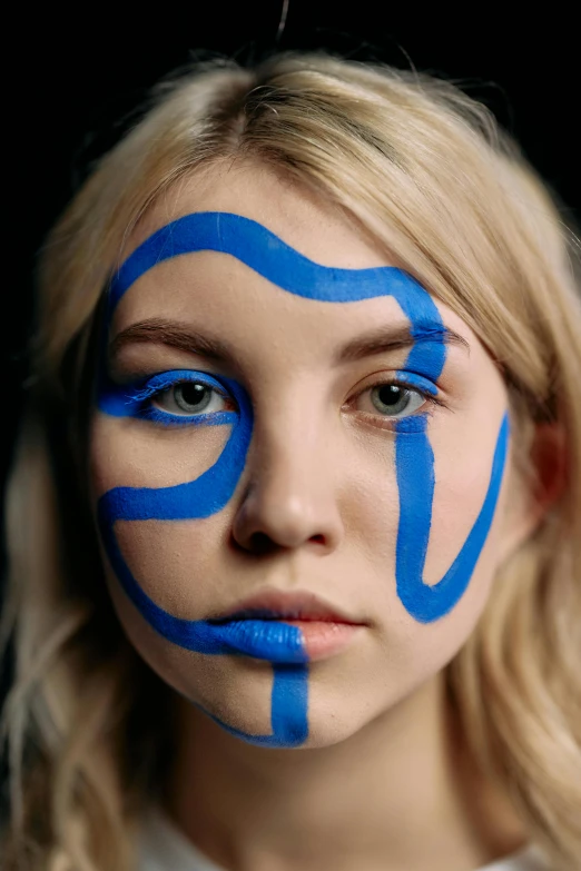a woman with blue paint on her face, an album cover, reddit, visual art, chloë grace moretz, swirly body painting, portrait anya taylor-joy, photographed for reuters