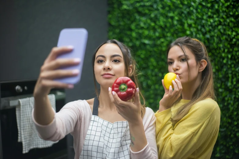 a couple of women standing next to each other, a picture, trending on pexels, with apple, bad selfie, cuisine, pr shoot