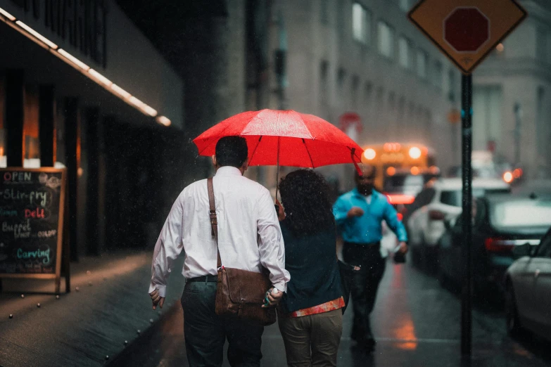 a man and woman walking in the rain with an umbrella, pexels contest winner, deep color, instagram post, red umbrella, humans of new york