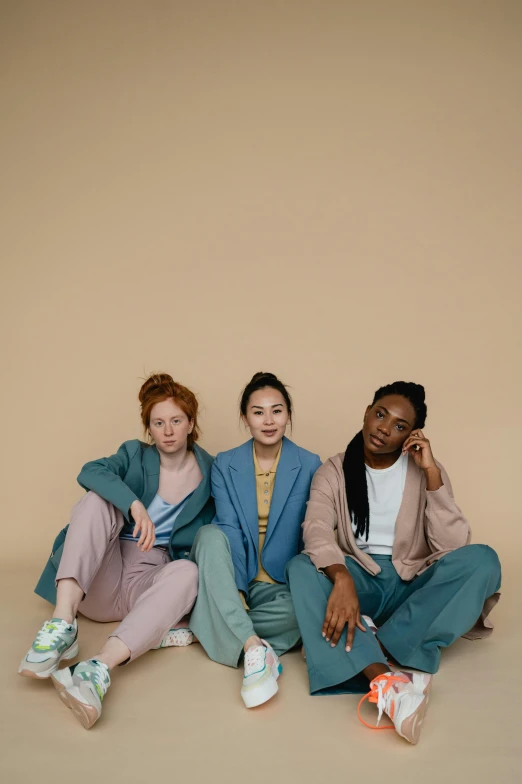 a group of three women sitting next to each other, by Louisa Puller, trending on pexels, renaissance, wearing a track suit, muted colors with minimalism, wearing a colorful men's suit, asian human