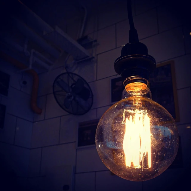 a close up of a light bulb with a clock in the background, by Jesper Knudsen, pexels contest winner, realism, cafe lighting, lomography photo, rustic, instagram picture