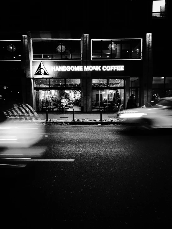 a black and white photo of a coffee shop at night, by Dimitre Manassiev Mehandjiysky, cinematic. by leng jun, car shot, speed, instagram picture