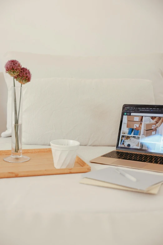 a laptop computer sitting on top of a bed, visual art, table in front with a cup, white, vanilla, product image