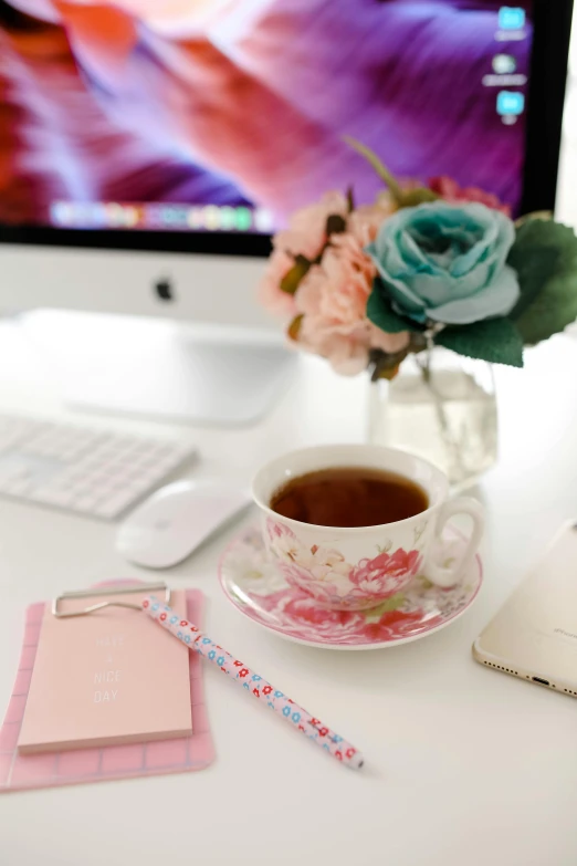 a computer monitor sitting on top of a desk next to a cup of coffee, by Dulah Marie Evans, pink rose, floral patterned skin, influencer, tea