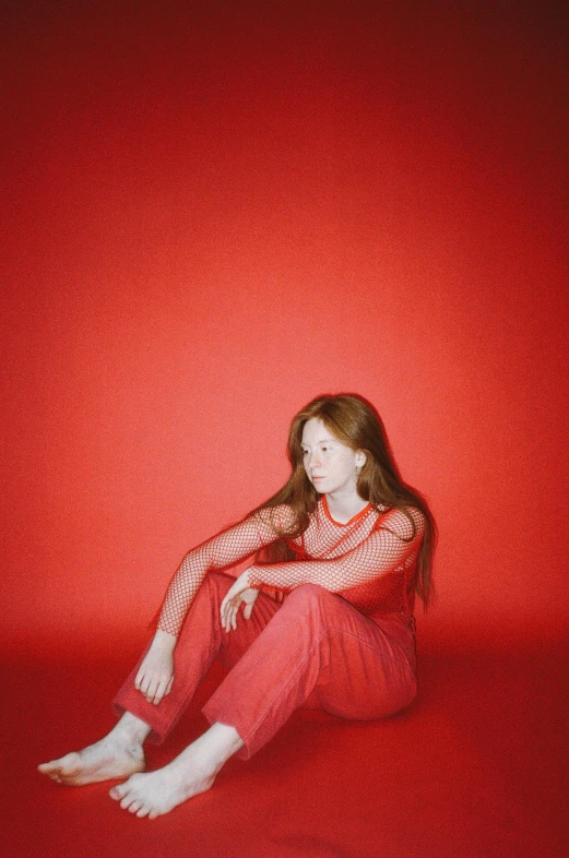 a woman sitting on top of a red floor, an album cover, inspired by Elsa Bleda, trending on pexels, renaissance, brown red long hair, kim doyoung, leaked image, red suit