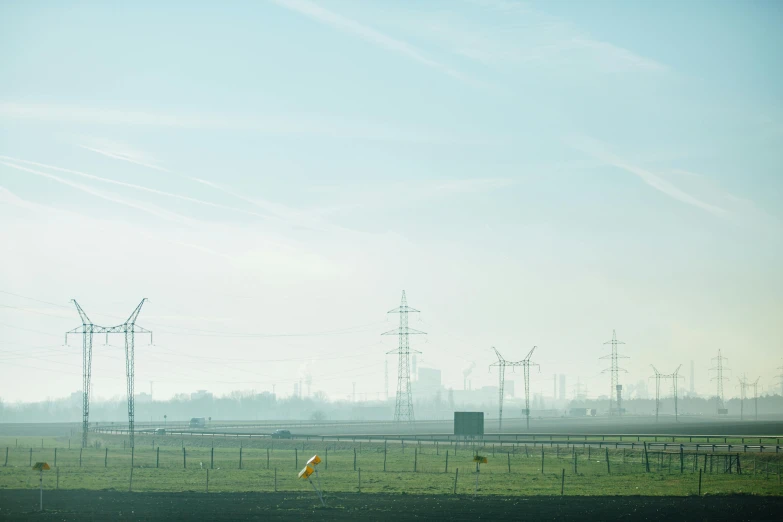 a herd of cattle standing on top of a lush green field, by Jacob Toorenvliet, happening, pylons, city of industry, midday photograph, van lieven