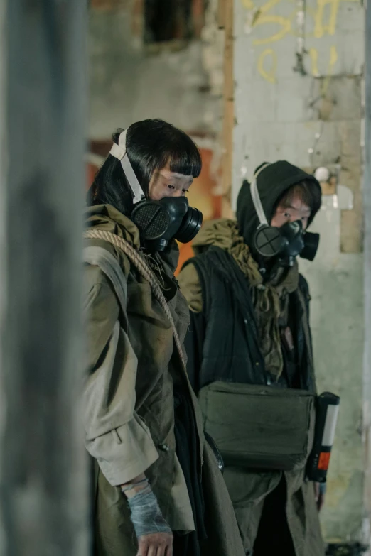 two men in gas masks standing next to each other, photograph of a techwear woman, still from a live action movie, pentagon, wearing dirty travelling clothes