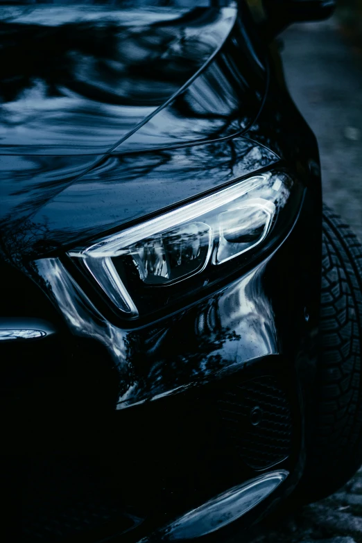 a black car parked on a cobblestone street, by Adam Marczyński, pexels contest winner, photorealism, closeup shot of face, headlight washer, hydrogen fuel cell vehicle, close - up profile