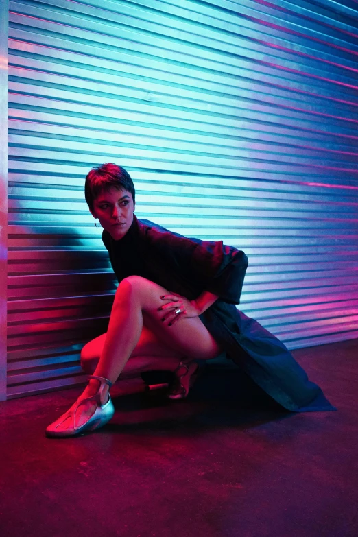 a woman sitting on a skateboard in front of a wall, an album cover, by Emanuel Witz, pexels contest winner, pixie cut with shaved side hair, neon lighting medium full shot, isabela moner, kneeling at the shiny floor