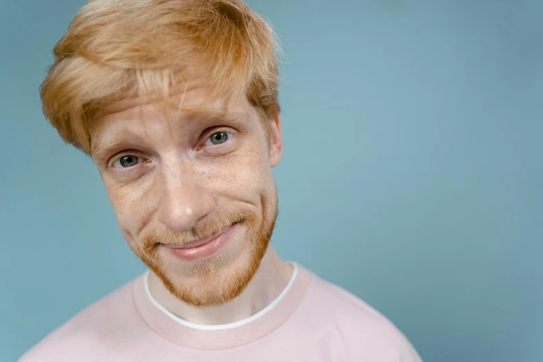 a close up of a person wearing a pink shirt, trending on pexels, hyperrealism, looks like domhnall gleeson, happily smiling at the camera, sparse freckles, red beard