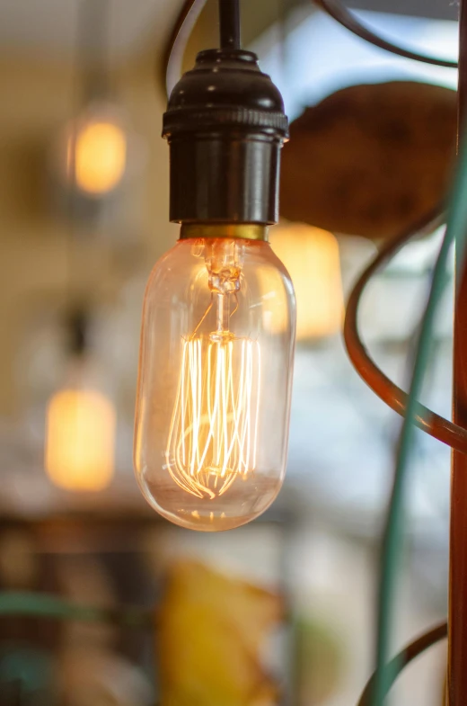 a close up of a light bulb on a pole, by David Simpson, pexels, warm lighting interior, vintage inspired, cafe lighting, small nixie tubes