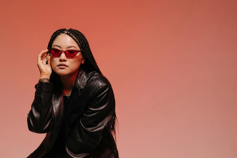 a woman in a black leather jacket and red sunglasses, inspired by Zhu Da, trending on pexels, visual art, gradient red, various posed, asian descent, studio lit