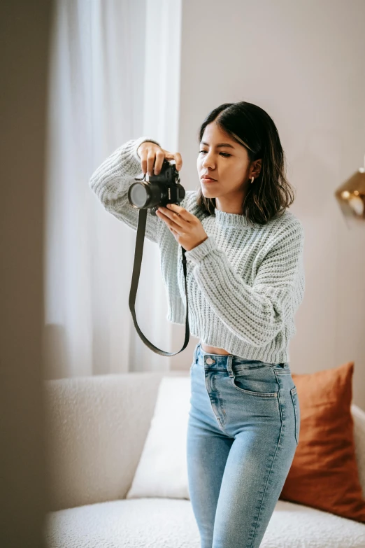 a woman taking a picture of herself with a camera, a picture, inspired by Elsa Bleda, unsplash contest winner, wearing casual sweater, natural light in room, young asian woman, 5 0 0 px models