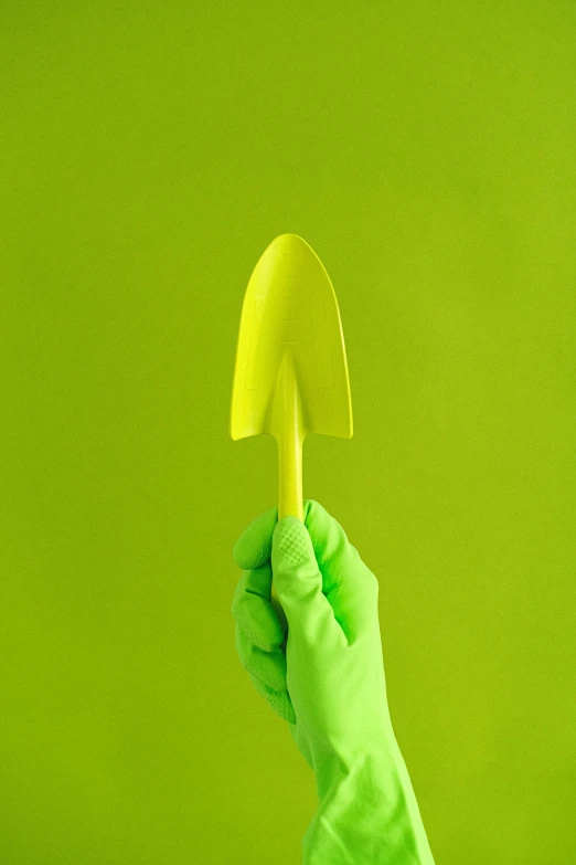 a person in green gloves holding a yellow shovel, pexels contest winner, conceptual art, organic shape, blade design, 🐿🍸🍋, profile image