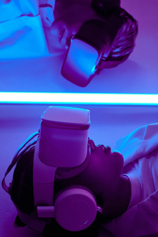 a person laying on the ground with headphones on, renaissance, glowing visor, colorful medical equipment, ultra facial detail, hospital lighting