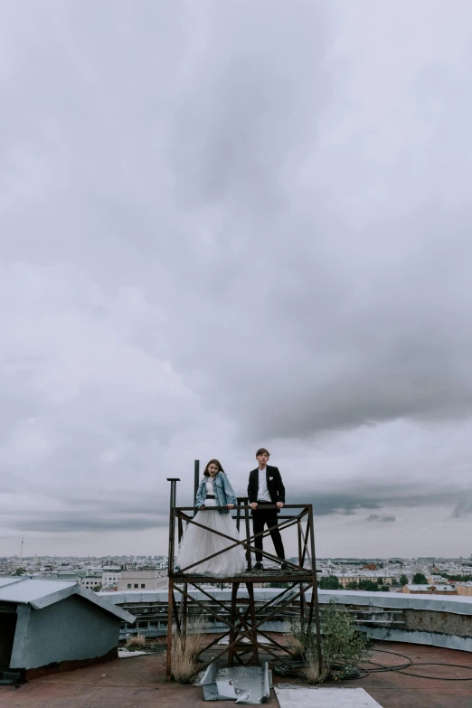 a group of people standing on top of a building, cloudy weather, jovana rikalo, two people, sitting on a metal throne