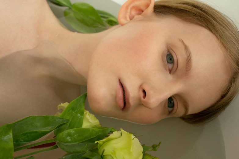 a close up of a person in a bath tub with flowers, inspired by Anna Füssli, unsplash, hyperrealism, young boy, natural soft pale skin, on a pale background, perfect face and boy