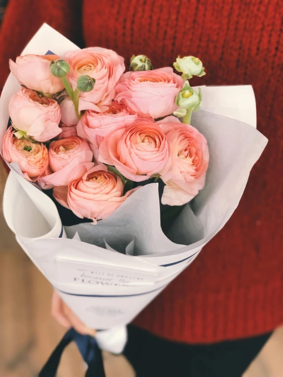 a woman holding a bouquet of pink roses, by Julia Pishtar, trending on unsplash, instagram story, in shades of peach, sweet hugs, flower shop scene