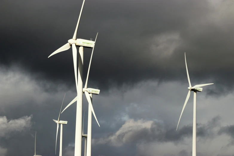 a group of wind turbines on a cloudy day, by Carey Morris, pexels contest winner, hurufiyya, dynamic closeup, a green, grey, white