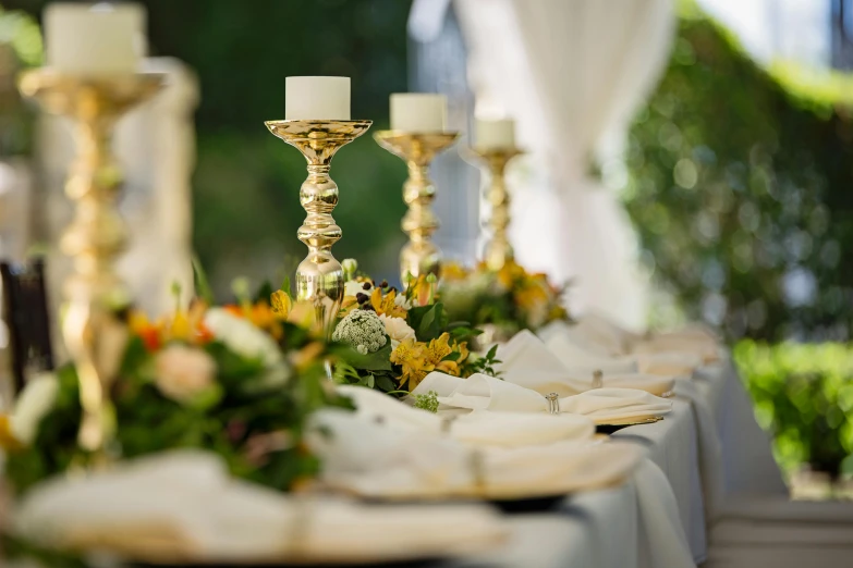 a table that has a bunch of plates on it, unsplash, romanticism, gold and white robes, outdoor lighting, long table, on a candle holder