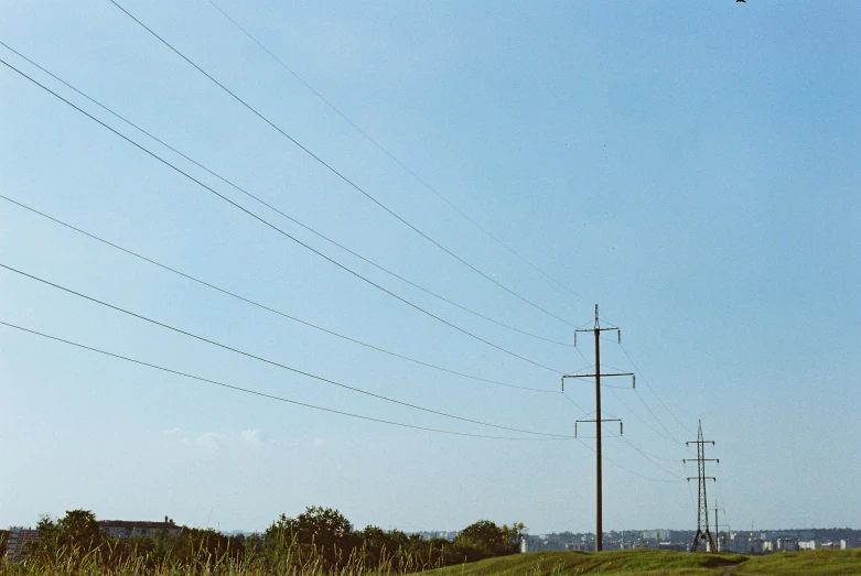 a man flying a kite on top of a lush green field, inspired by Thomas Struth, unsplash, hyperrealism, power lines, ignant, nadav kander, 1999 photograph