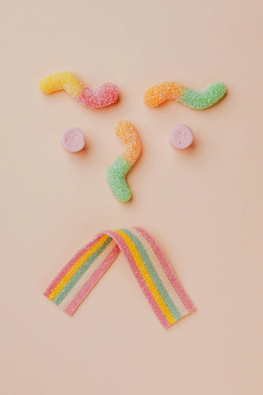 candy candies are arranged in the shape of a man's face, inspired by George Aleef, trending on pexels, tentacles beard, muted rainbow tubing, soft and fluffy, detailed product image