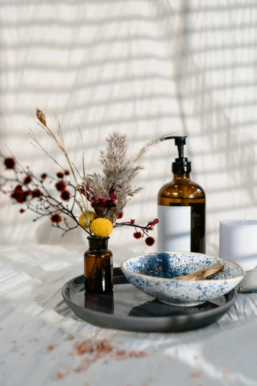 a close up of a plate of food on a table, a still life, by Zofia Stryjenska, trending on unsplash, vases and bottles, soap, brown flowers, blue and black color scheme