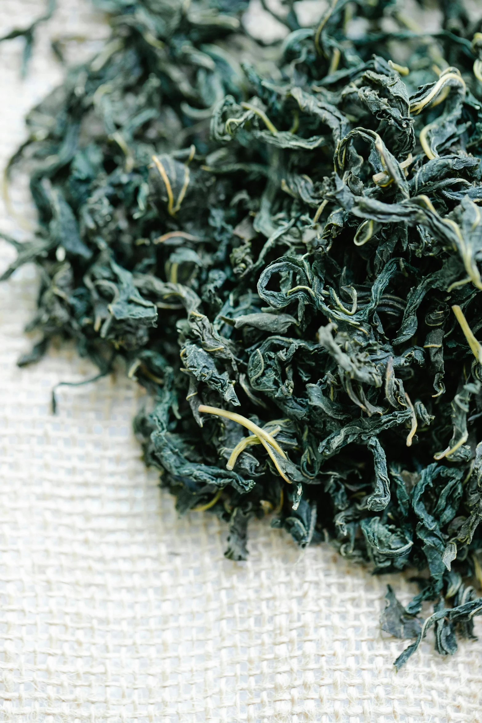 a pile of green tea sitting on top of a table, hurufiyya, fine foliage lace, zoomed in, organic ink, battered