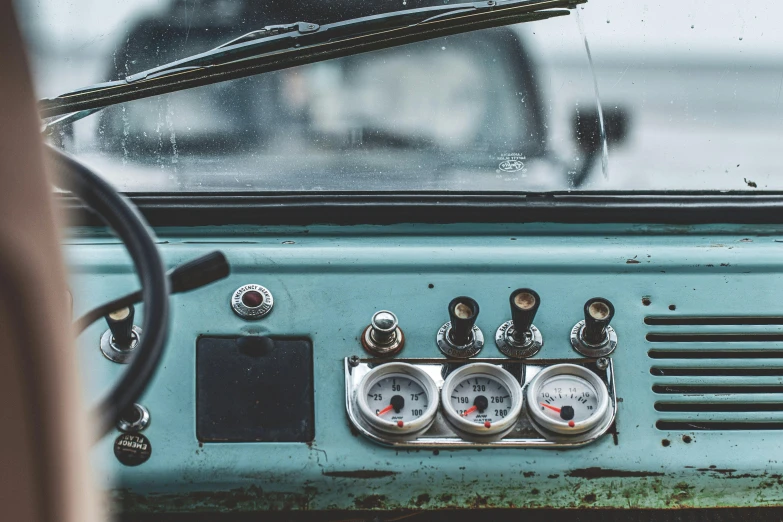 a close up of a car dashboard with gauges, by Adam Marczyński, trending on unsplash, turquoise rust, land rover defender, vintage photo, “the ultimate gigachad