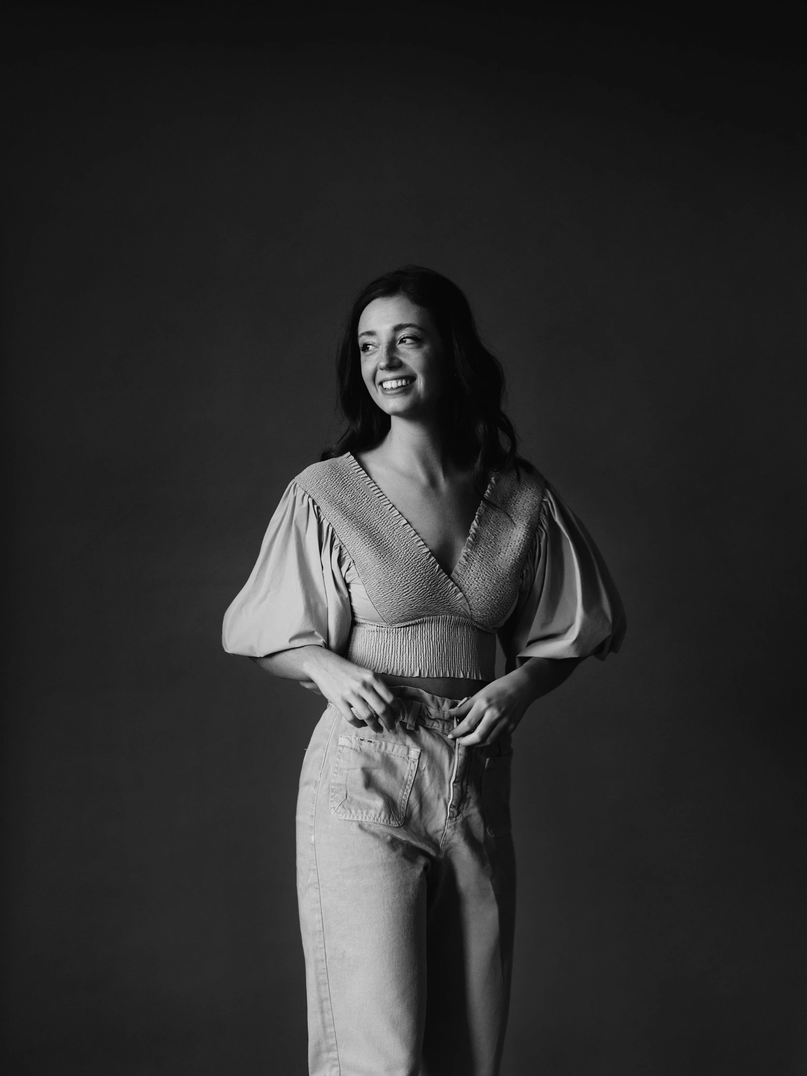 a woman standing in a black and white photo, a black and white photo, by Adam Marczyński, charli bowater, smiling, artem chebokha, official product photo