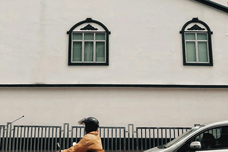 a person riding a motorcycle on a city street, by Carey Morris, pexels contest winner, postminimalism, house windows, 🦩🪐🐞👩🏻🦳, gray and orange colours, like jiufen