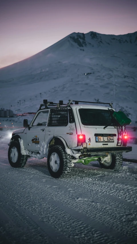 a white jeep driving down a snow covered road, by Olaf Gulbransson, pexels contest winner, hurufiyya, tail lights, square, fully armoured, profile