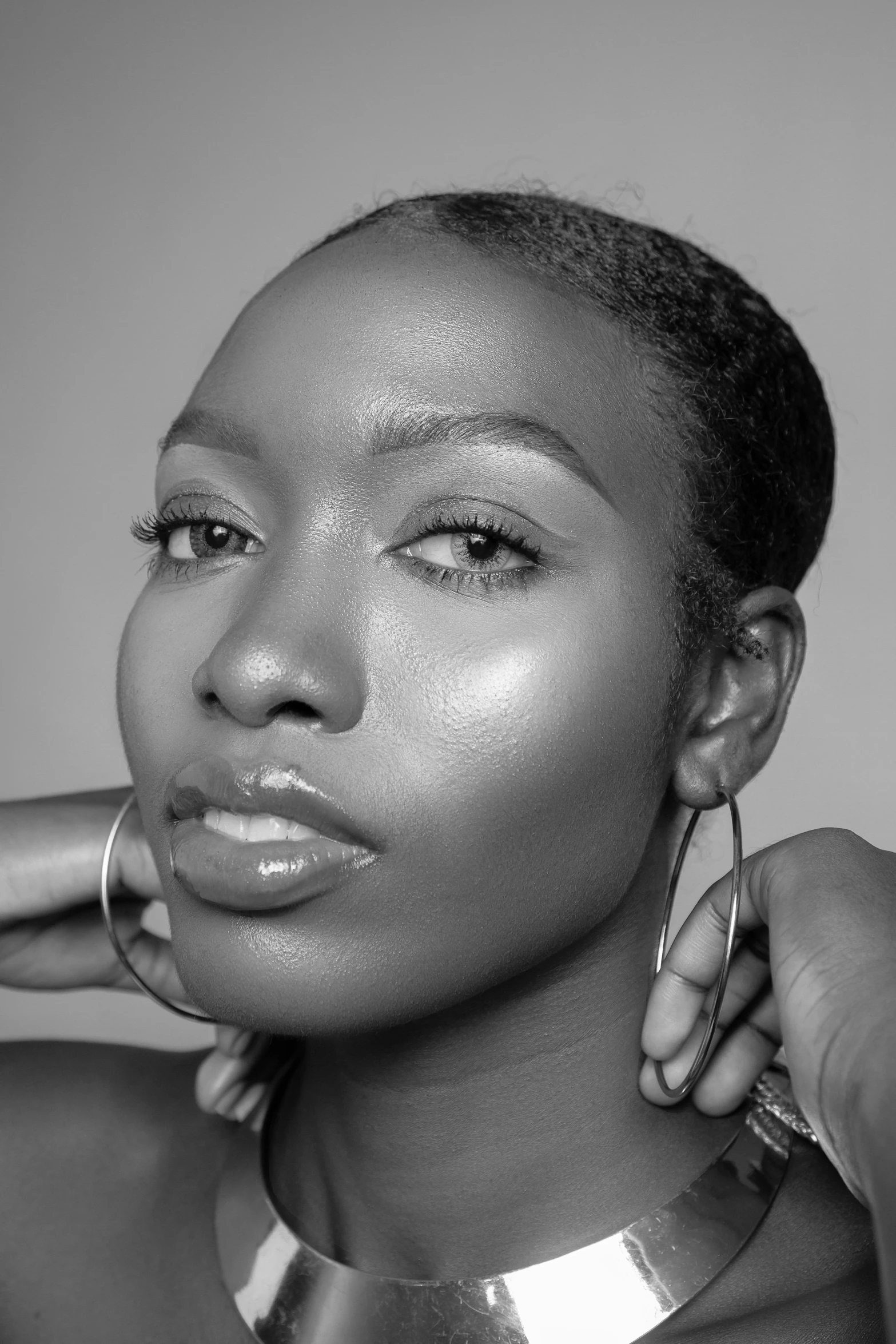a black and white photo of a woman wearing a choke, inspired by Theo Constanté, pexels contest winner, afrofuturism, relaxed eyebrows, gleaming silver, naomi campbell, tapered hairline