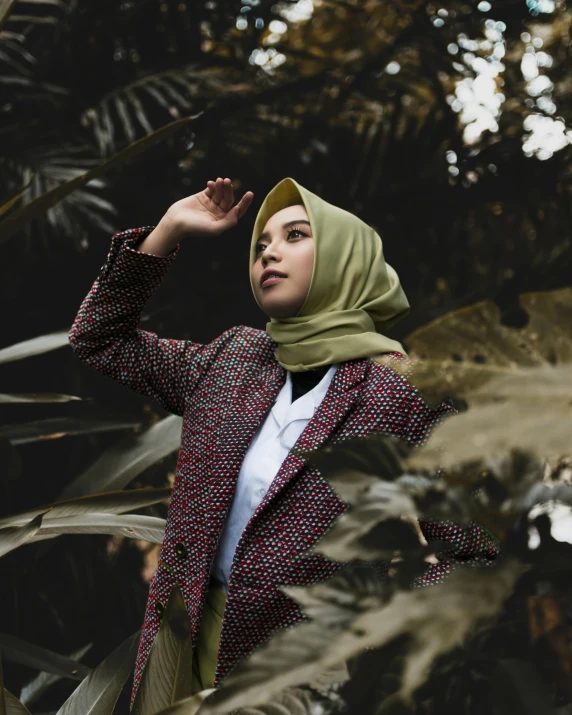 a woman in a hijab poses for a picture, a colorized photo, inspired by Elsa Bleda, trending on pexels, sumatraism, foliage clothing, wearing a blazer, non binary model, in jungle