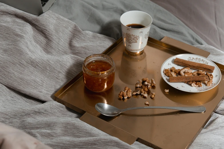 a tray of food sitting on top of a bed, a still life, inspired by Anna Füssli, trending on pexels, copper cup, caramel, detailed product image, detail shot