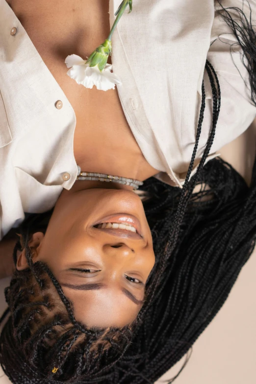 a woman with dreadlocks laying on her stomach, by Cosmo Alexander, trending on pexels, happening, arm around her neck, smiling down from above, photoshoot for skincare brand, upsidedown