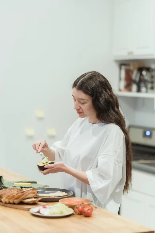 a woman standing in a kitchen preparing food, inspired by Yukimasa Ida, pexels contest winner, on a white table, profile image, young woman with long dark hair, plated